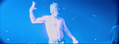 a shirtless man with a mask on performing on stage