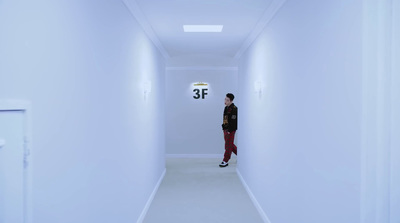 a man is standing in a white hallway