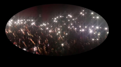 a crowd of people holding up their cell phones