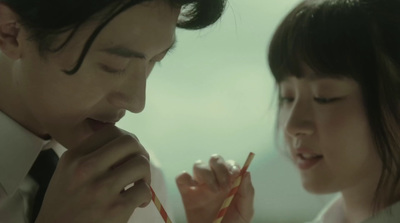 a man and a woman holding chopsticks in their hands