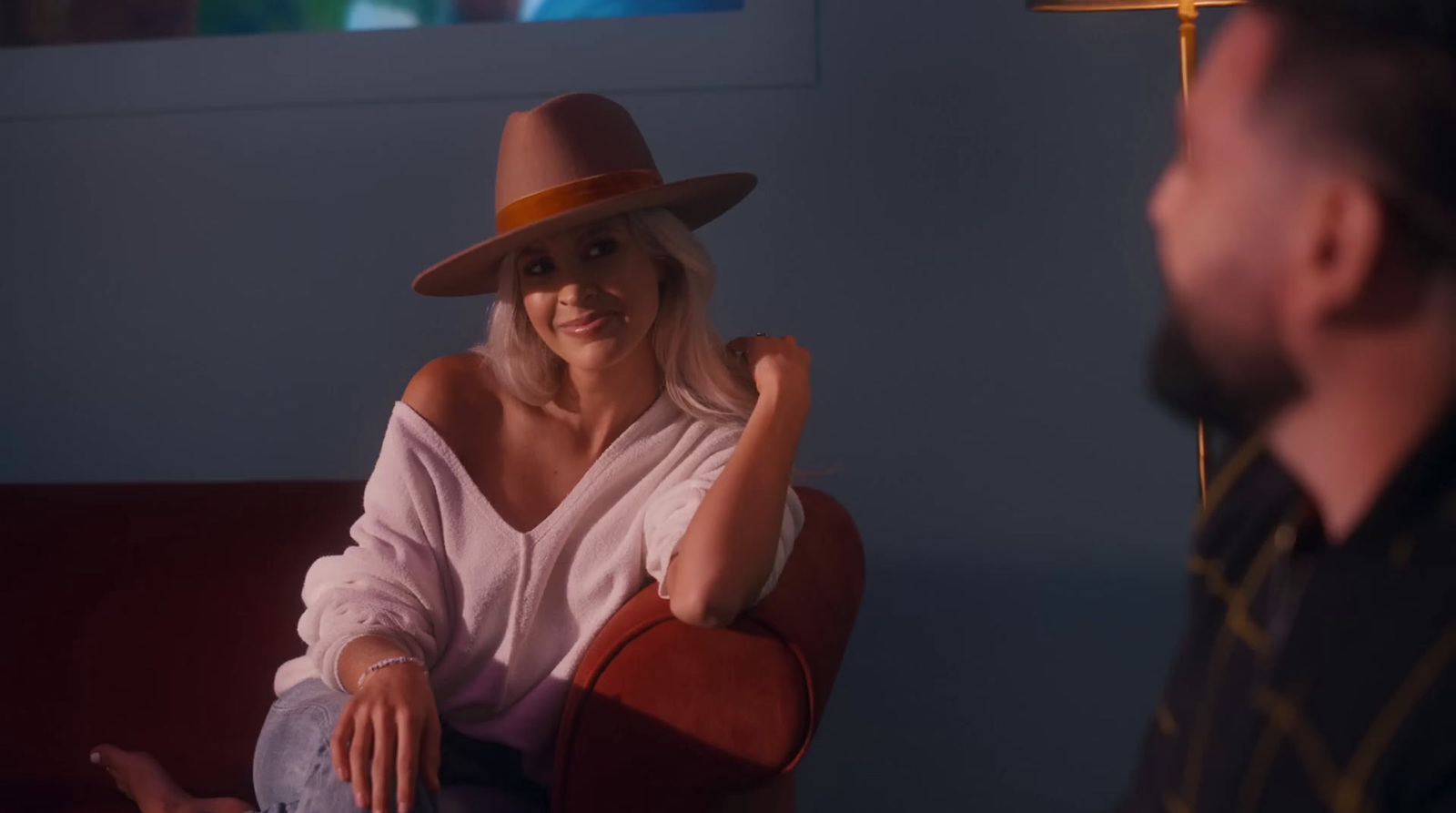 a woman sitting on a red couch next to a man