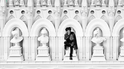 a black and white photo of a person sitting on a bench