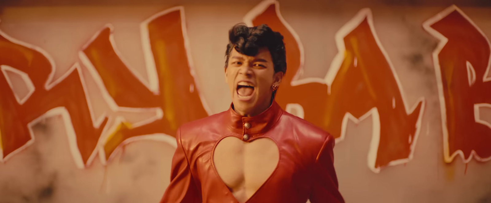 a man in a red suit with a heart cut out of his chest