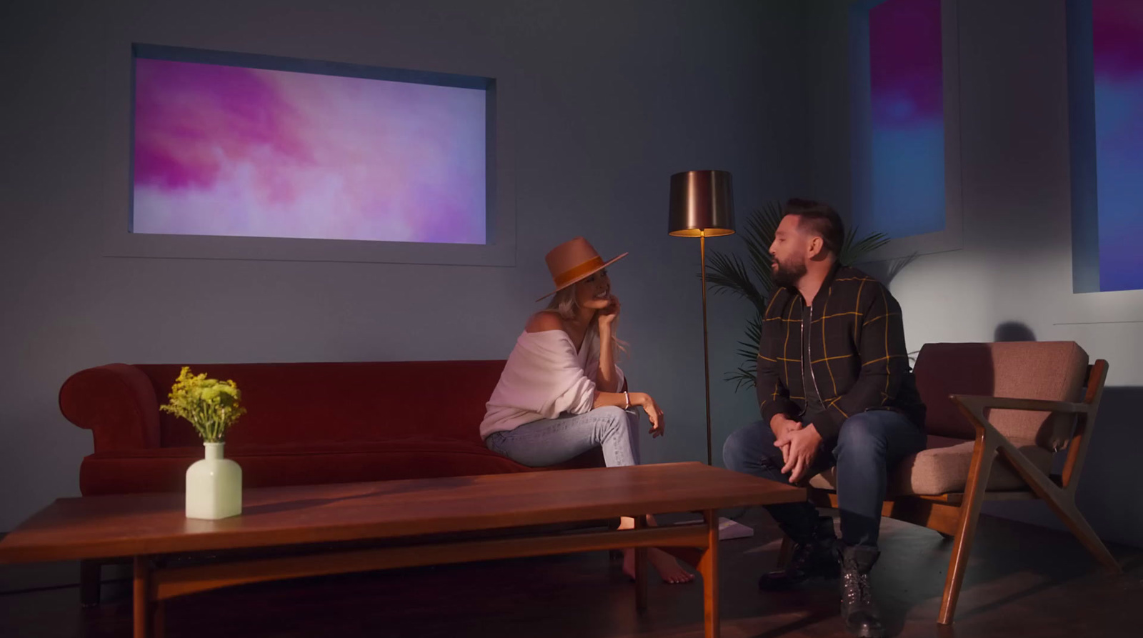 a man and a woman sitting on a couch in a living room