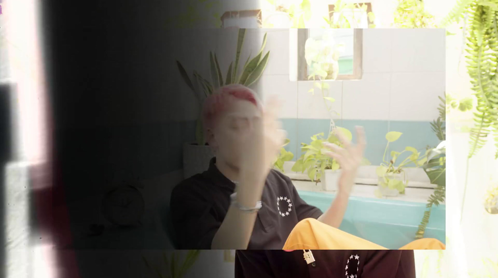 a person sitting in a bath tub with a plant in the background