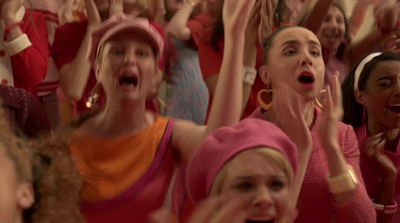 a group of women singing into microphones in front of a crowd