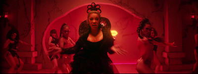 a woman in a black dress dancing in a red room