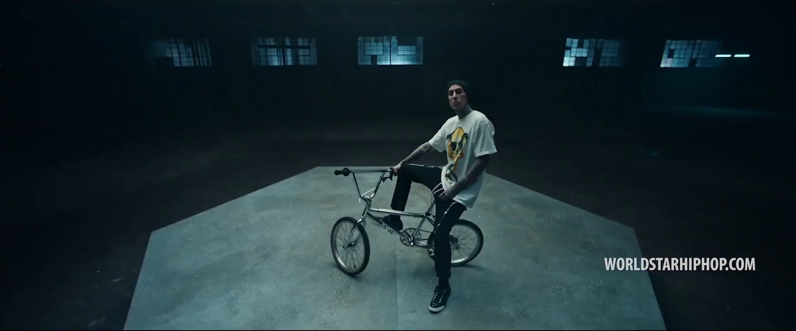 a man sitting on top of a bike in a dark room