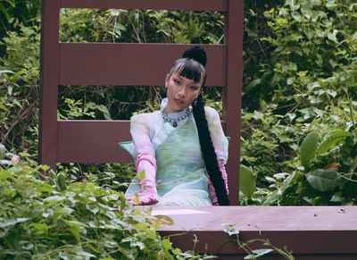 a woman sitting on a bench in a garden