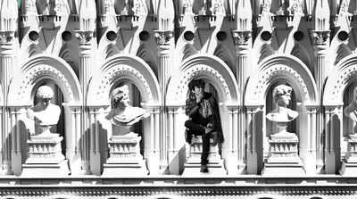 a person sitting on a bench in front of a building