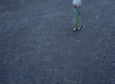 a little girl walking across a street holding an umbrella