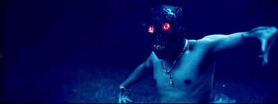 a shirtless man with red eyes and a chain around his neck