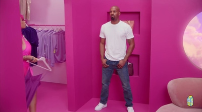 a man standing in a pink room next to a woman