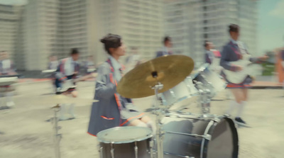 a group of people standing around a drum set