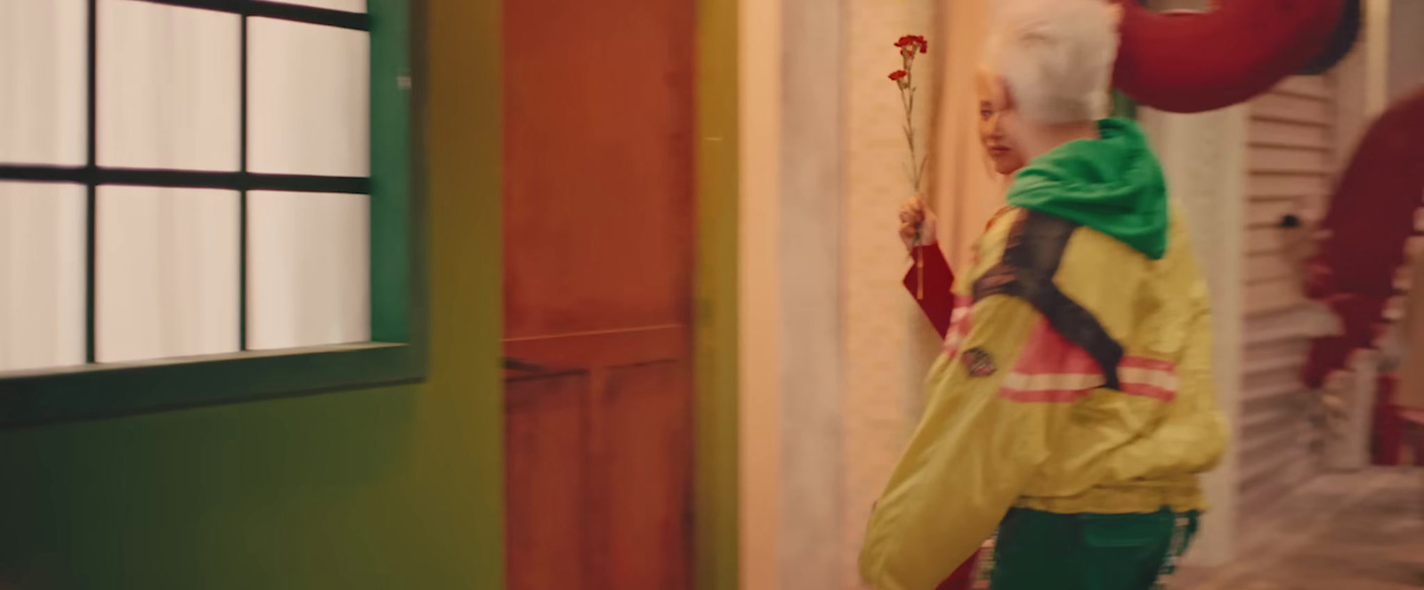 a person in a yellow rain coat holding a red umbrella