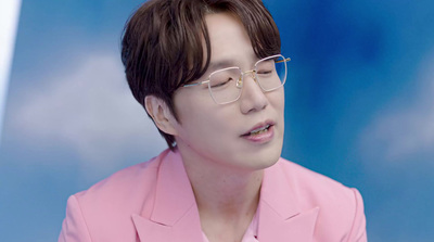 a man wearing glasses and a pink suit