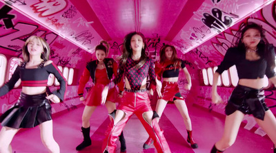 a group of young women dancing in a pink room