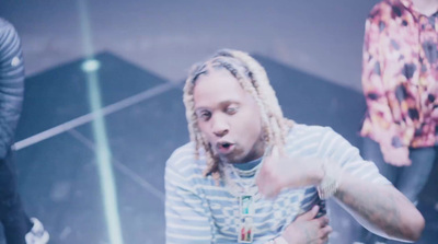 a man with dreadlocks standing in front of a mirror