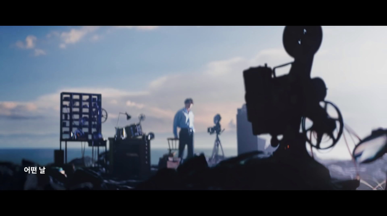 a man standing on top of a hill next to a camera