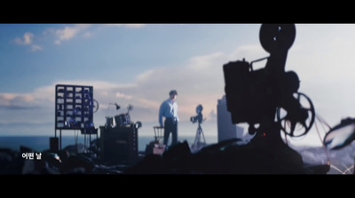 a man standing on top of a hill next to a camera