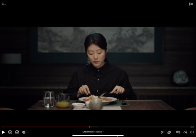 a woman sitting at a table with a plate of food