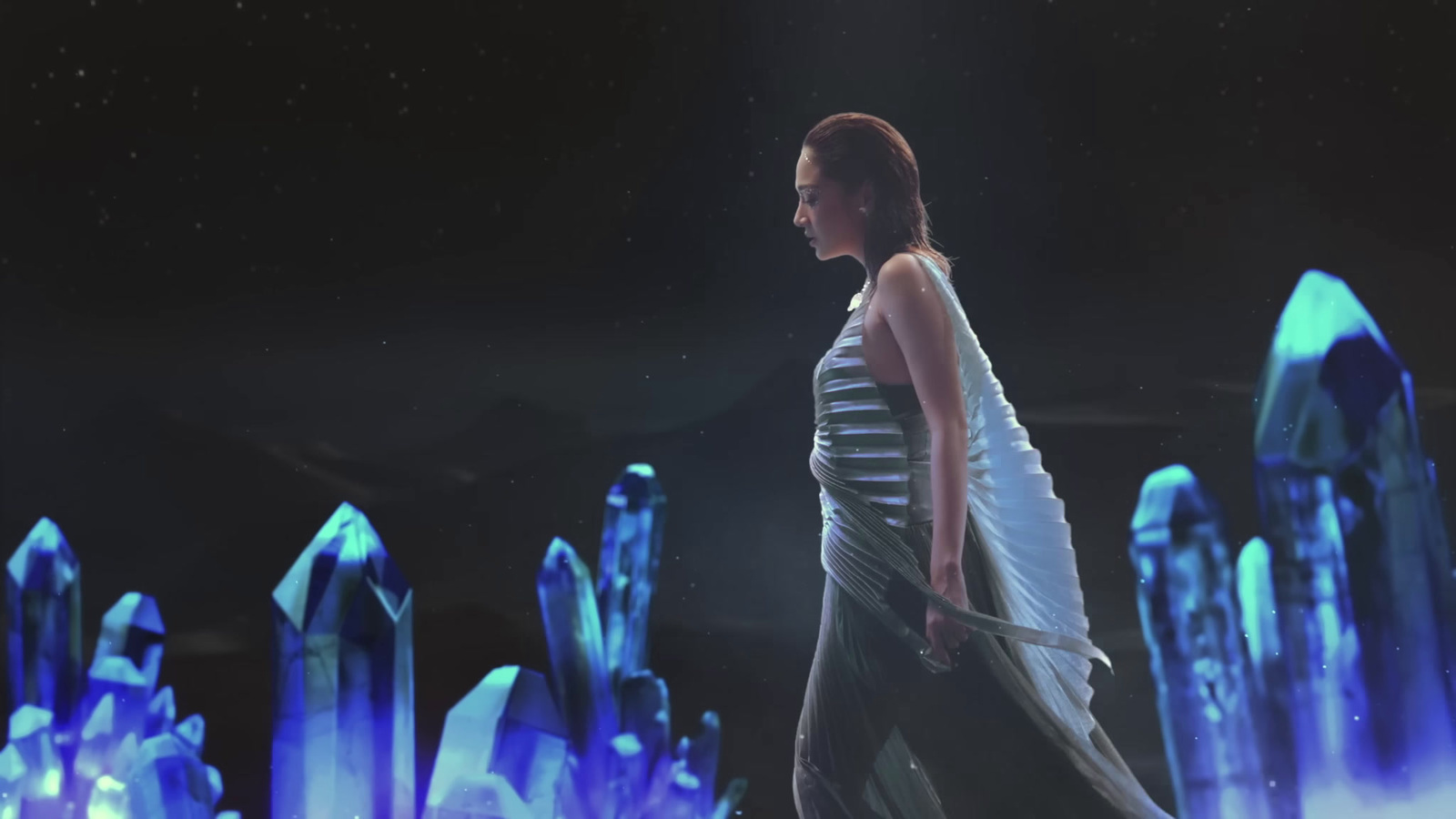 a woman in a striped dress walking in front of ice crystals