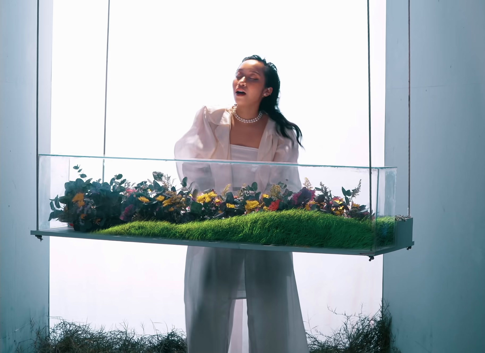 a woman standing in front of a display of flowers