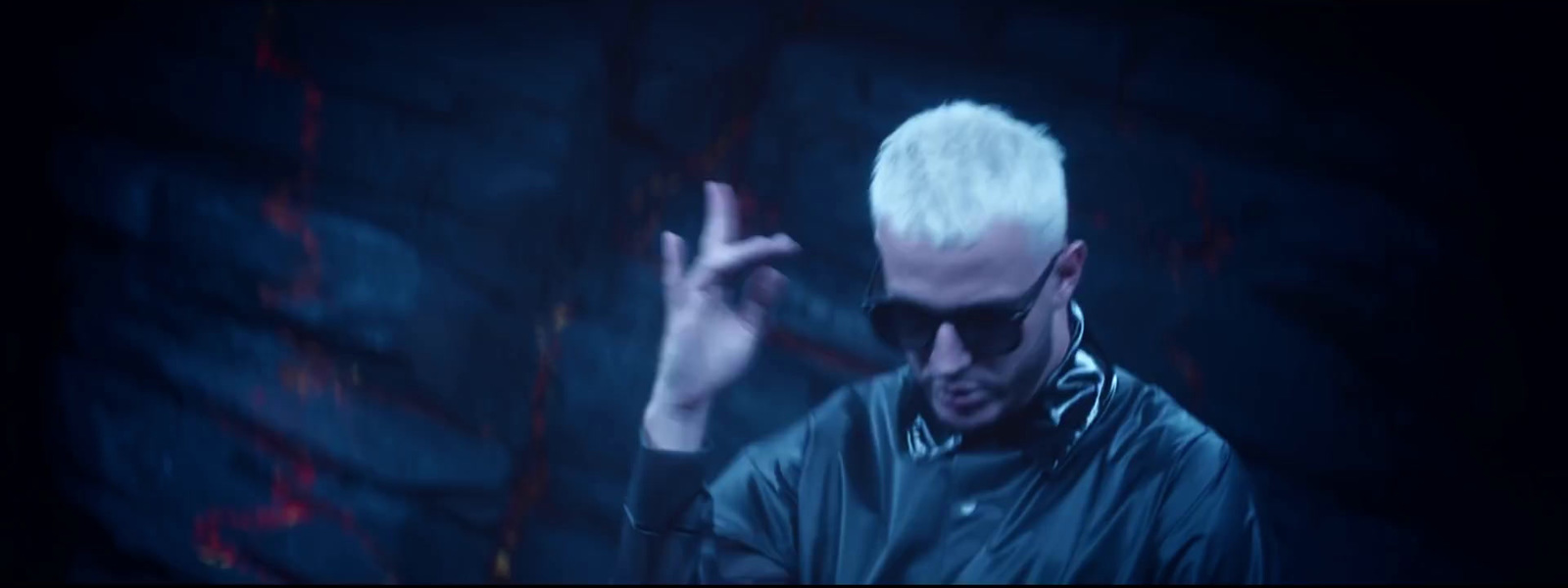 a man with white hair and sunglasses making a peace sign