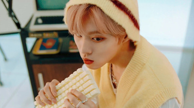 a person wearing a yellow sweater holding a corn cob