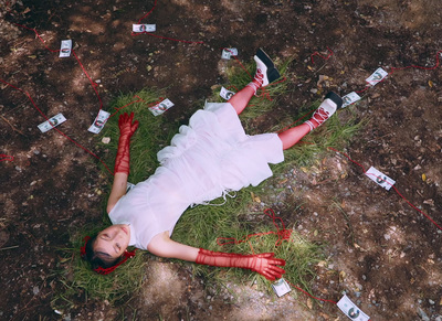 a woman in a white dress laying on the ground