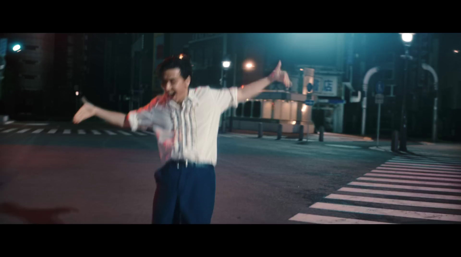 a man standing in the middle of a street at night