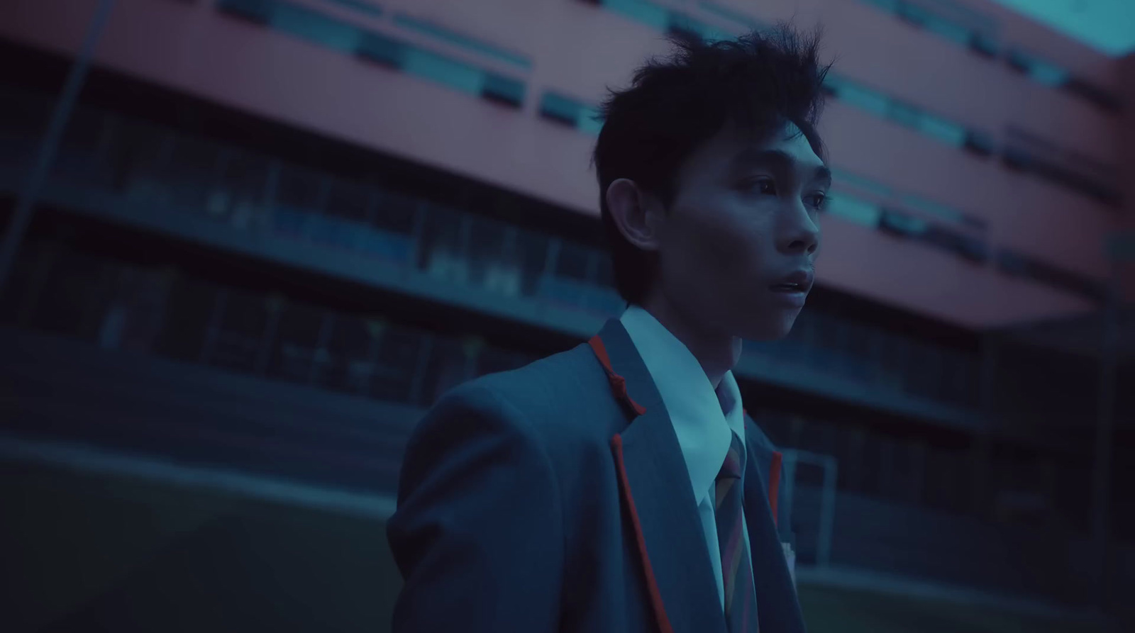 a man in a suit and tie standing in front of a building