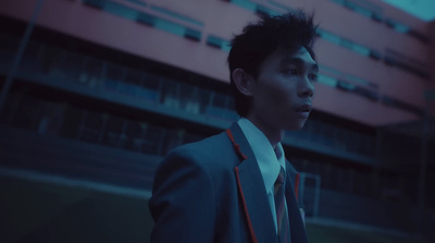 a man in a suit and tie standing in front of a building