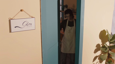 a man in an apron standing in a doorway