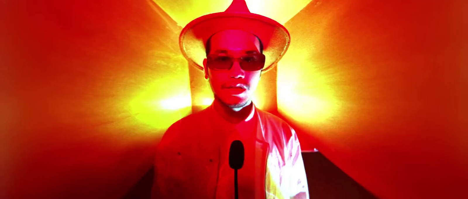 a man in a red light room with a microphone