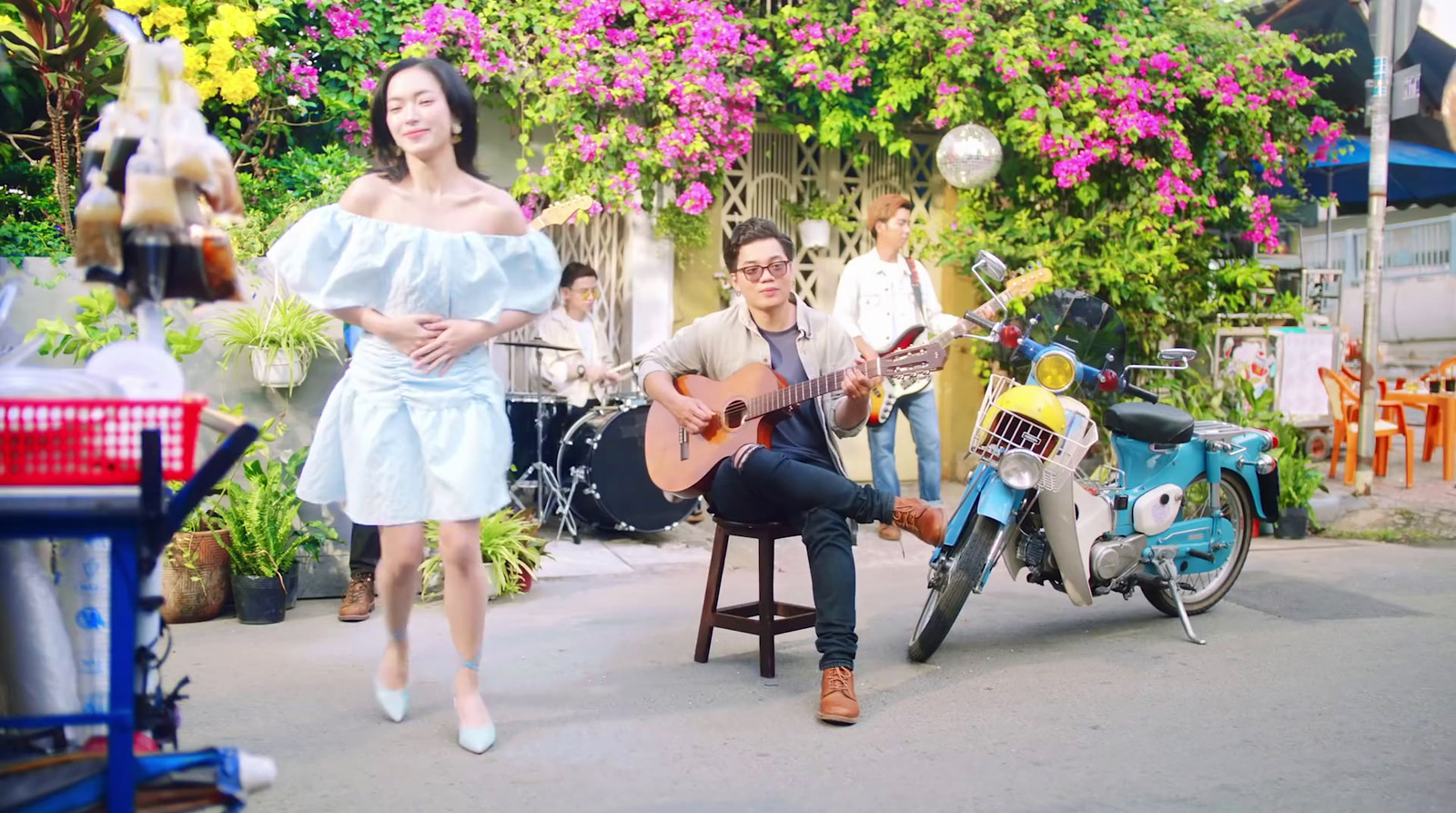 a man sitting on a chair next to a woman playing a guitar