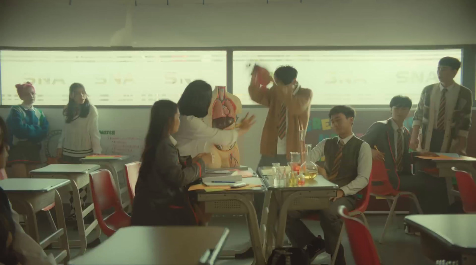 a group of people sitting at desks in a classroom