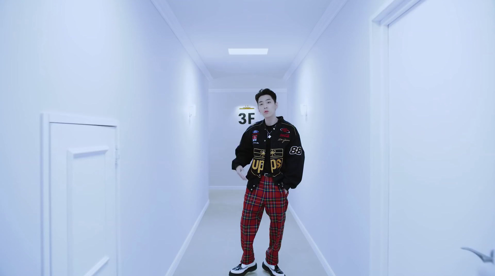 a man standing in a hallway with a jacket on