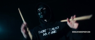 a person in a black hoodie holding a stick