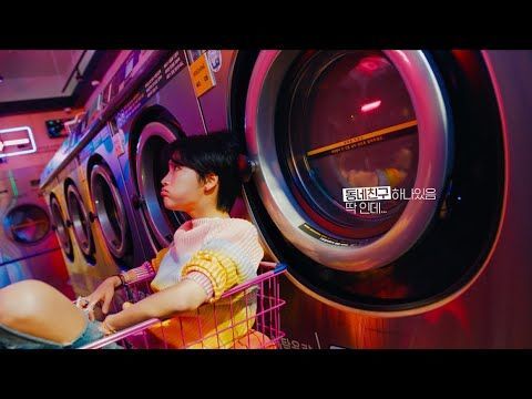 a woman sitting in a shopping cart in front of a washing machine