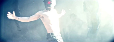 a shirtless man with a red light on his face