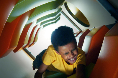 a young boy sitting in a chair with a smile on his face