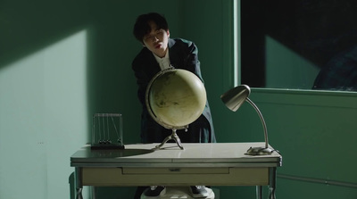 a woman standing in front of a desk with a globe on it