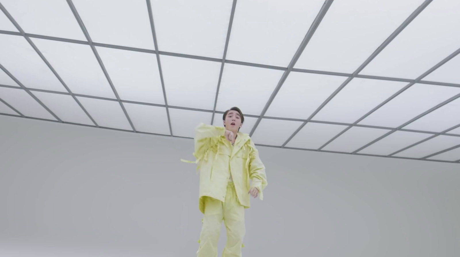 a man in a yellow suit standing in a room