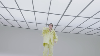 a man in a yellow suit standing in a room