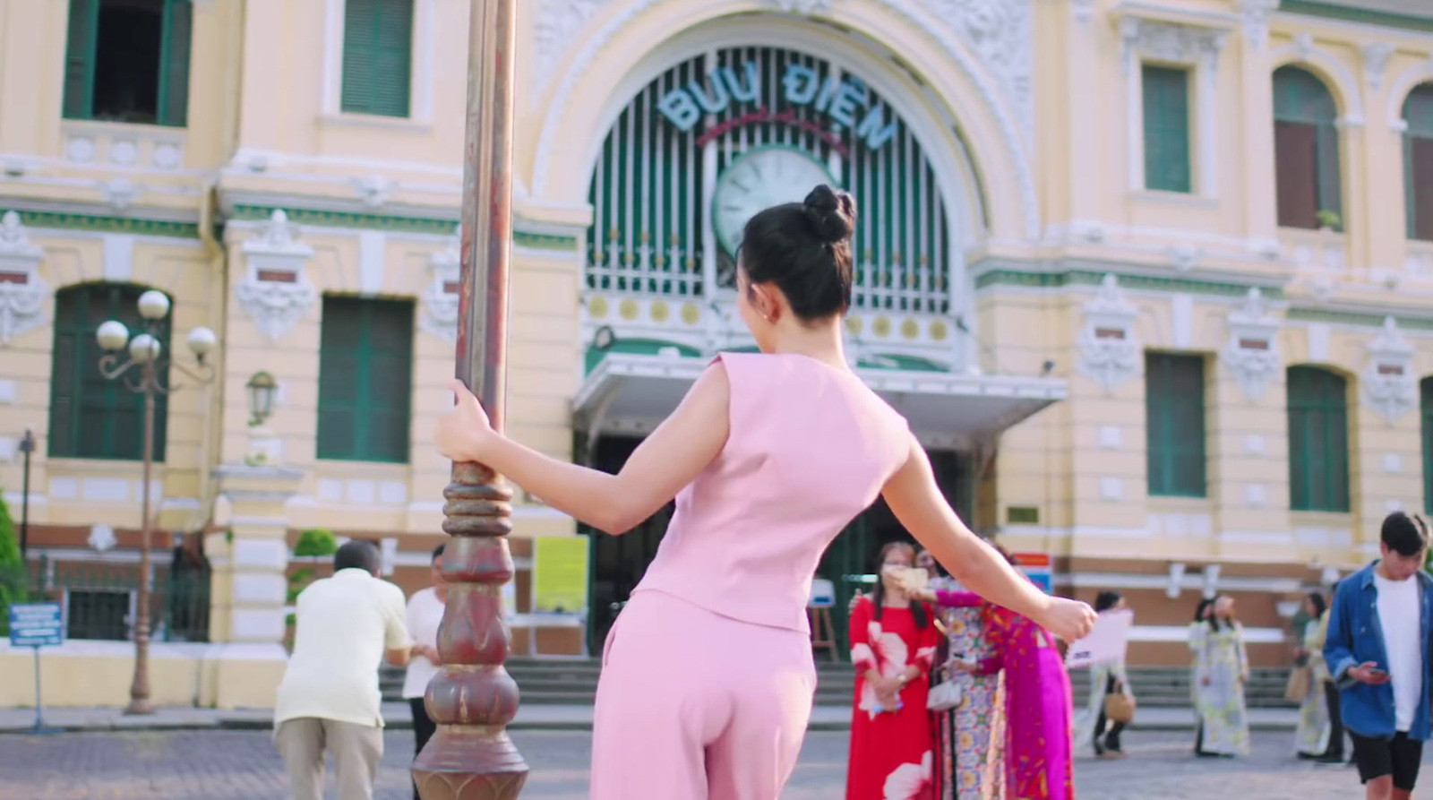 a woman in a pink jumpsuit holding an umbrella