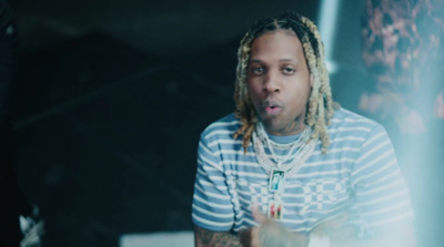 a man with dreadlocks sitting in front of a mirror