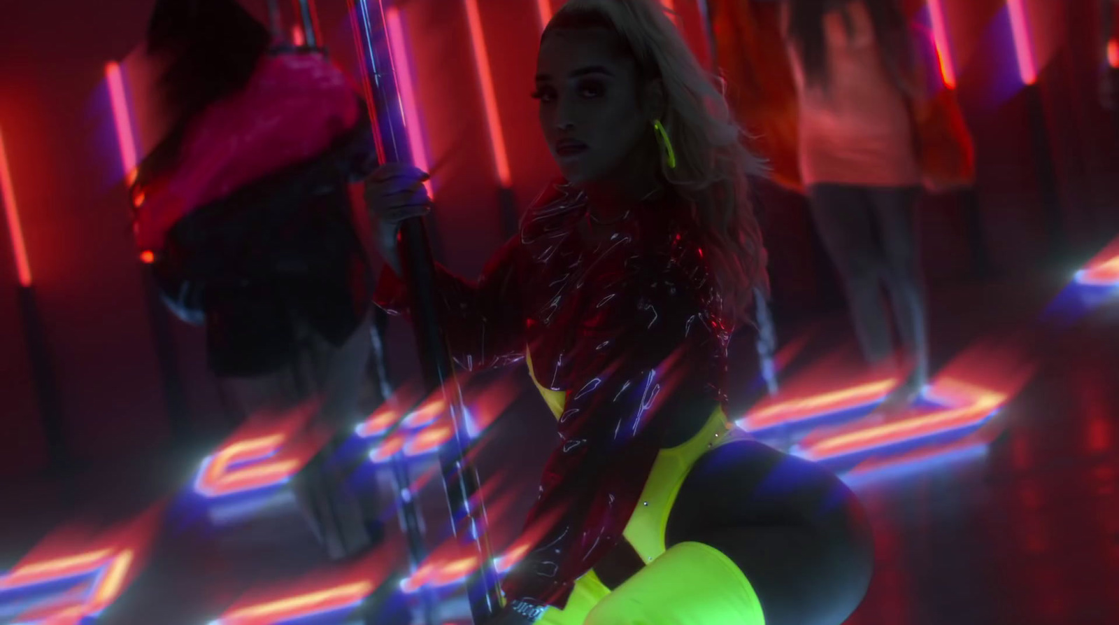 a woman in a neon outfit holding a pole