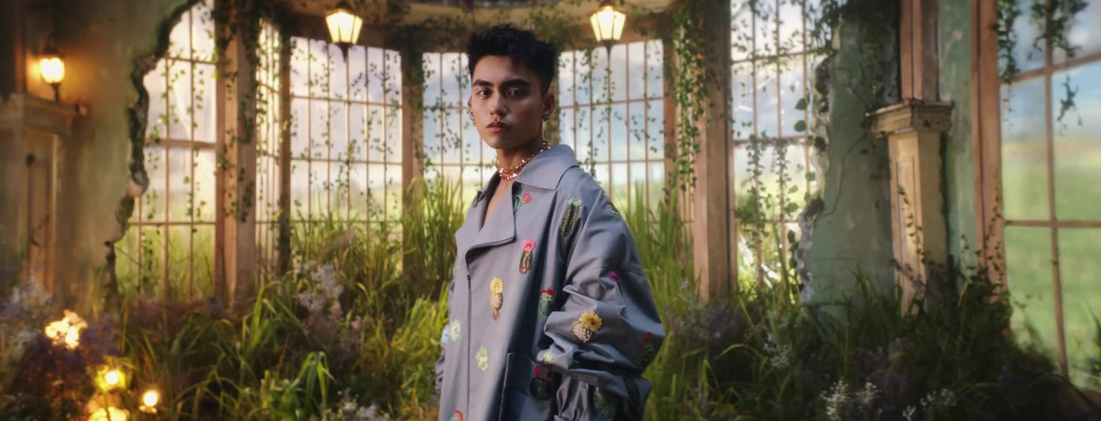 a man standing in front of a window in a room filled with plants