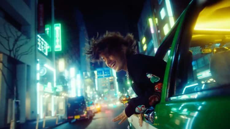 a man leaning out the window of a green car